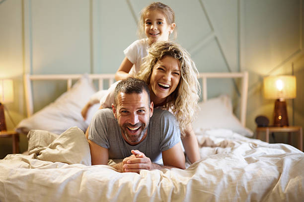 istock Happy family making human pyramid on a bed. 2238910052