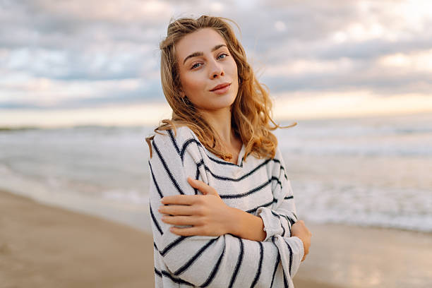 istock A young woman stands on a beach during sunset 2238912740