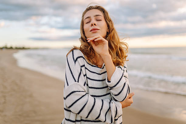 istock A young woman stands on a beach during sunset 2238912756
