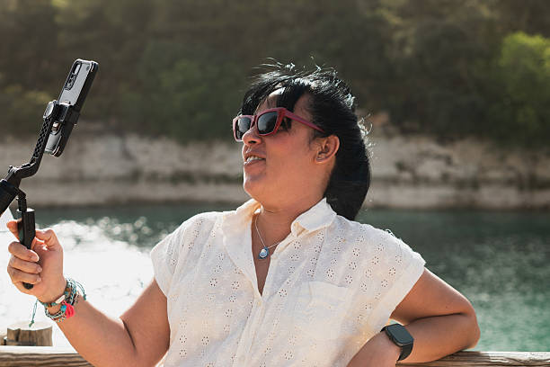 istock Woman vlogging outdoors, creating travel content by lake 2238913229
