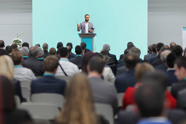 istock Man holding a book on stage in front of an audience 2238913297