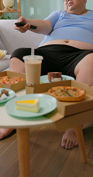 istock obese man eating junk food 2238914250