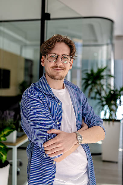 istock Young man confidently working in a modern office environment with plants around him and a positive expression 2238915007