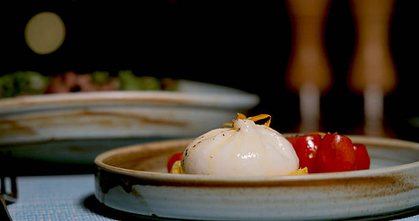 Burrata cheese with cherry tomatoes on ceramic plate, Italian