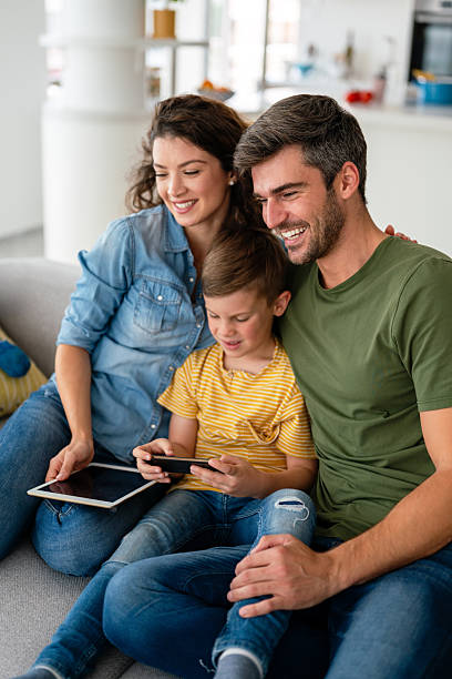 istock Parents with kid having fun online with application watching video cartoon or playing game on tablet 2238920872