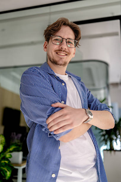istock Young man smiles confidently while working in a modern office environment, showcasing professionalism and engagement in his tasks 2238920873