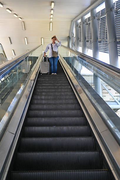A female tourist grips the handrail while feeling dizzy and suffering from a sudden headache during her journey.