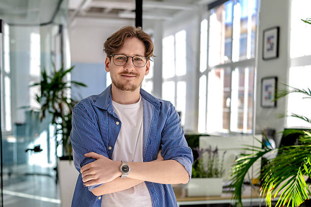 istock Young professional man smiles confidently in modern office environment while engaged in freelance work 2238924987