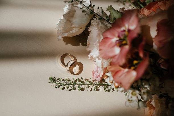 istock Wedding Rings with Floral Background on Tabletop 2238926109