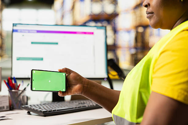 istock Warehouse worker in a hi-vis vest uses copy space display with technology 2238934480