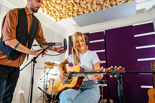 Female guitarist records in a professional studio during a warm, creative soundcheck session
