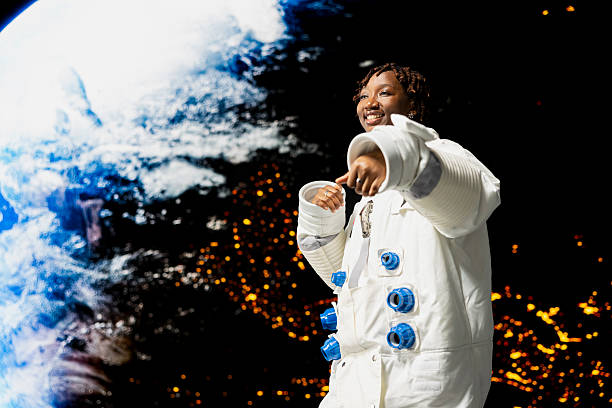 Joyous woman in cosmonaut suit doing dance moves, ecstatic to take part in planetary exploration research mission. Happy orbital station crew member excited by beauty of planet in space