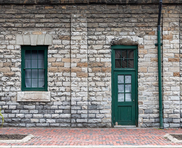 Old green frame window and door on weathered brick building