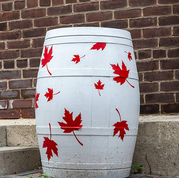 white barrel with red maple leaves against brick building close up
