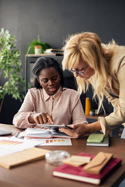 istock Businesswomen collaborating on tablet in office while discussing work 2238948984