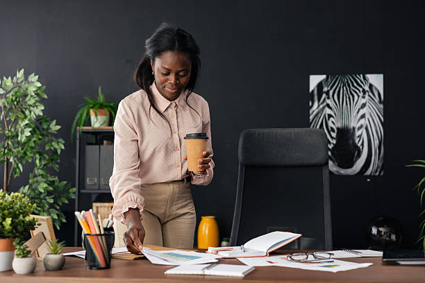 Black woman organizing paperwork at modern office desk