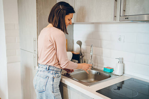 istock Woman washes the dishes 2238952680