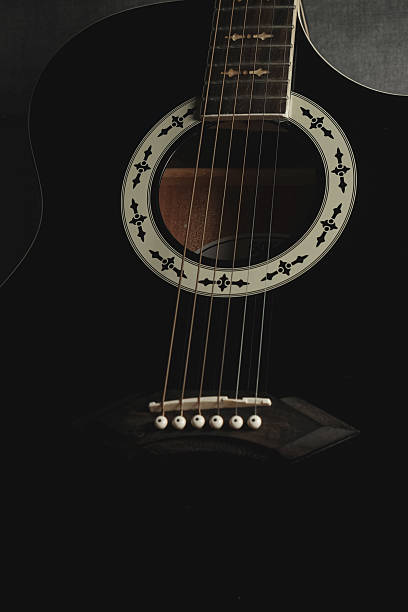 istock Black acoustic guitar resting on dark background showcasing intricate design 2238952741