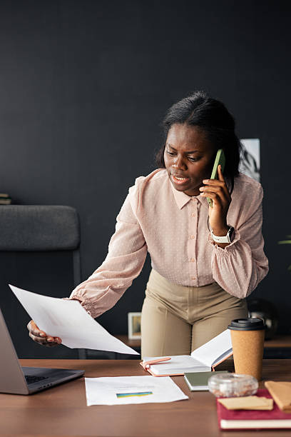istock Stressed businesswoman working, talking on phone, holding documents 2238954525