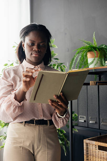 istock Black woman reading notebook in modern office 2238955904