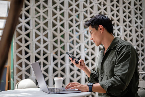 istock Young professional in casual outfit multitasking at a cafe table, representing remote work, digital lifestyle, and focused productivity. 2238962685