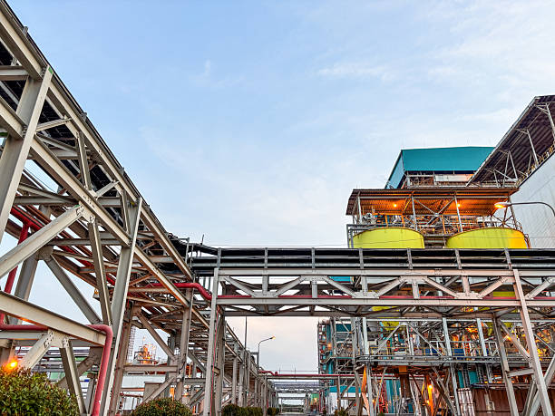 istock Industrial refinery architecture shows complex steel structures with yellow tanks at dusk sky 2238964670