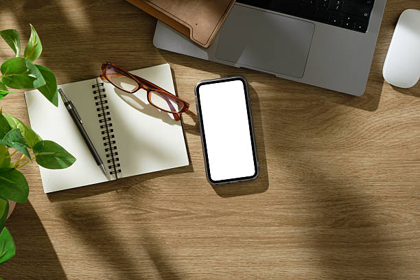istock Creative desk including laptop, mobile phone with blank screen, and planner in natural lighting. 2238964897