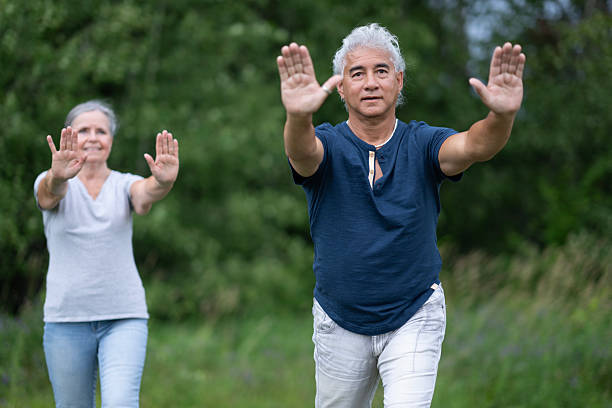 istock Senior Couple Outdoors Doing Balance Exercise With Hands Raised In Park 2238965144