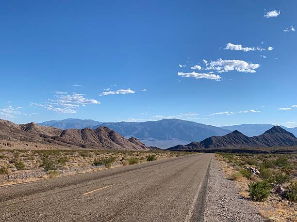 istock Empty Desert Highway Leading Toward Mountains in Death Valley, California 2238973233