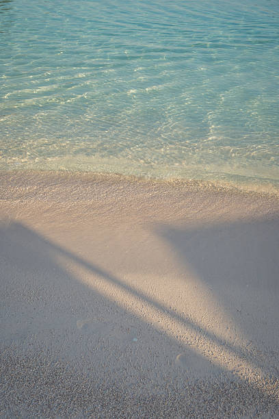 istock Calm turquoise shoreline with gentle wave and soft sand, vertical copy space 2238975179