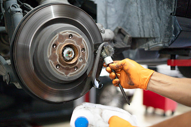 istock Mechanic cleaning car brake disc during maintenance service 2238977001