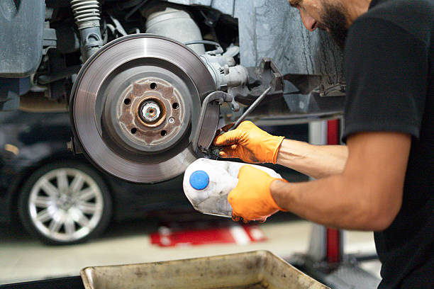 istock Mechanic servicing brake disc system on lifted car 2238977388