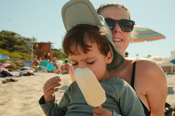 4-year-old girl having ice cream on a ​beach near the sea