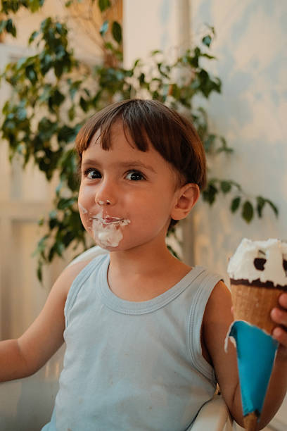 istock Boy eating messy ice cream in summer 2238979599