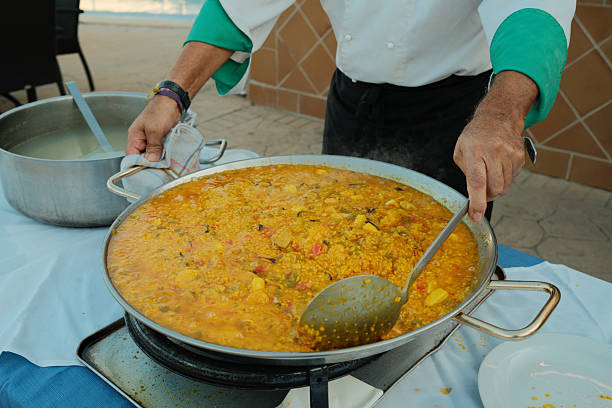 Seafood paella, isolated on a white background. Seafood paella tapa, served in a clay bowl. Spanish food concept.