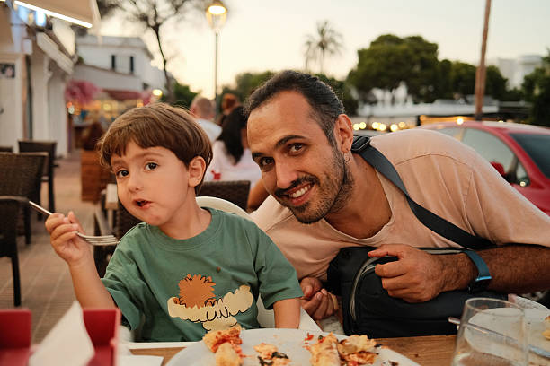 istock Father and son enjoying dinner at outdoor restaurant 2238979679
