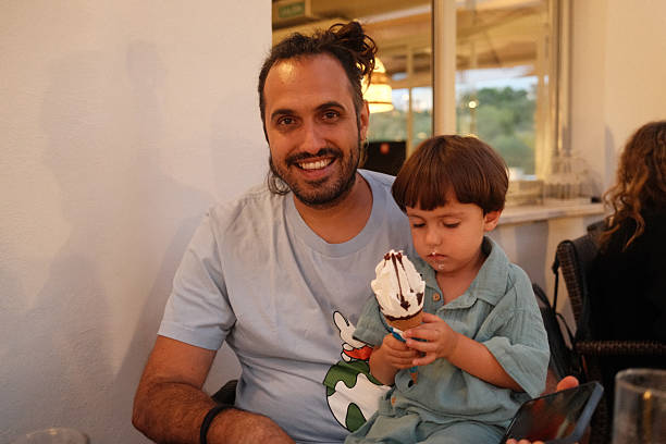 istock Father smiling with son eating messy chocolate ice cream 2238979686