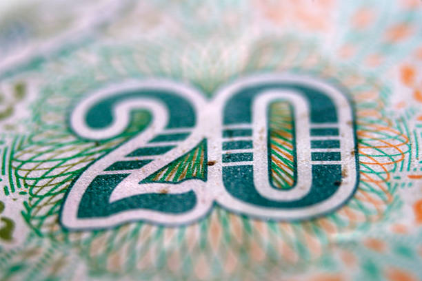 A detailed macro shot of a twenty dollar bill emphasizing the intricate patterns and textures. This image highlights the significance of currency in the economy.
