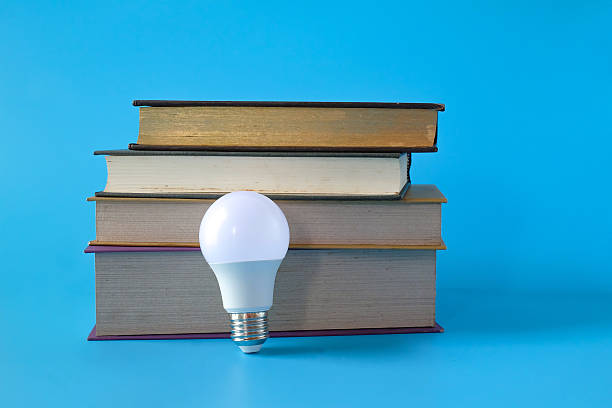 istock Light bulb and hard cover books on background. 2238982988