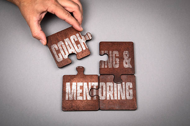 istock Coaching and Mentoring Concept. Wooden puzzle pieces with text on a gray background 2238985774