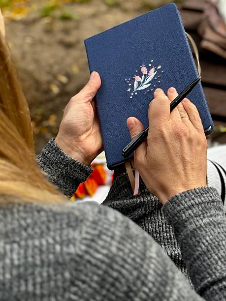 istock woman writes on a notebook in an autumn park 2238987921