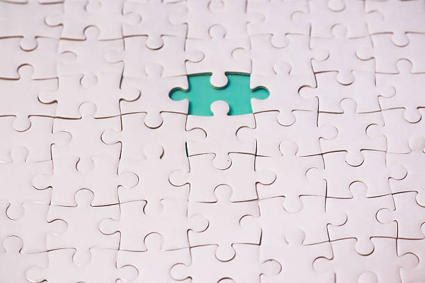 istock A completed white jigsaw puzzle with one missing piece revealing a green background 2238990763