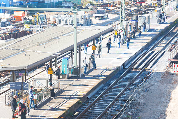 Commuters are waiting on a railroad station platform of the train station of Gelnhausen, Germany. The train station is currently undergoing extensive renovations; additional tracks are being laid for the Frankfurt-Fulda railway line (Germany-Hesse).