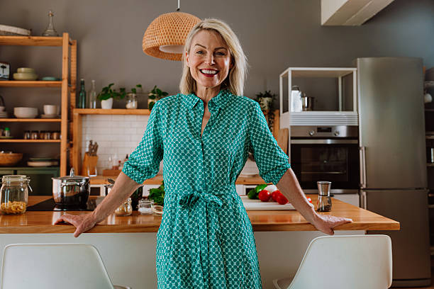 istock Smiling woman leaning on kitchen counter with fresh vegetables 2238999413