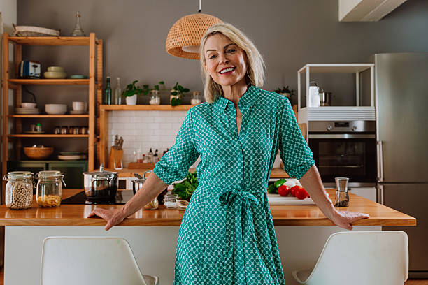 istock Smiling woman leaning on kitchen counter with fresh vegetables 2238999422