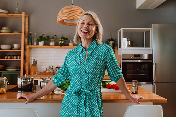 istock Smiling woman leaning on kitchen counter with fresh vegetables 2238999443