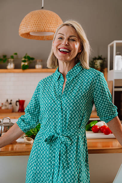 istock Smiling woman leaning on kitchen counter with fresh vegetables 2238999463