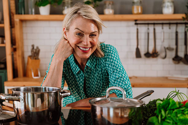 istock Smiling woman leaning on fresh vegetables in kitchen 2238999662
