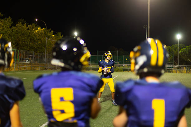 A american high school football quarterback turns to handoff the ball.