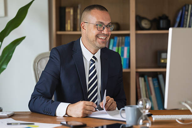 istock Professional businessman smiling while working on computer in home office 2239001486